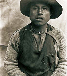 Foto: Hiram Bingham. Retrato de Enrique Porres, Uno de los obreros más inteligentes que nos ayudaron en las excavaciones de Machu Picchu. Se aprecia el abultamiento de su mejilla, que delata la presencia de un paquetito de coca, las hojas de la planta de la cual se extrae la cocaína. Casi todos los indios montañeses mascan hoja de coca. El paquetito se prepara con esmero al iniciar la jornada de trabajo, a media mañana, después de comer y a media tarde.