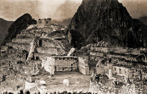 Foto: Hiram Bingham 26 / 40 Vista general de la Plaza Sagrada El emplazamiento de Machu Picchu donde se concentran los edificios que ostentan una mejor calidad arquitectónica. En el centro se yergue el Templo Principal; a la derecha, el templo de las Tres Ventanas. Sobre ambos templos descuella la colina sagrada, en cuya cima aguarda la piedra Intiwatana, o reloj de sol.