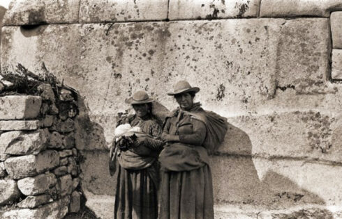 Foto: Hiram Bingham. Piezas clave. Las esposas de dos peones frente a la piedra más grande del muro oriental del Templo Principal de la Plaza Sagrada.
